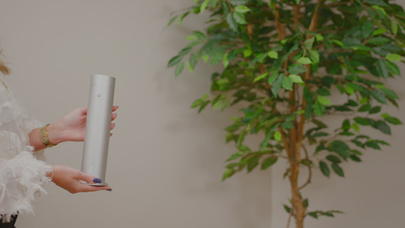Hand holding a Pip & Wells Pure One matte silver waterless aroma diffuser